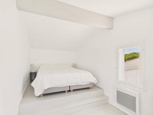 a white bedroom with a bed and a window at Saint Clément - 400 m plage - Cœur village in Saint-Clément-des-Baleines