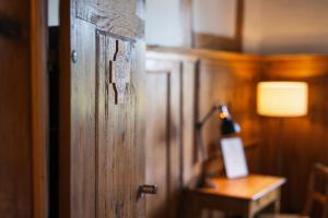 una porta in legno in una stanza con tavolo e lampada di Klosterherberge Solothurn Self Check-in a Solothurn