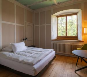 una camera da letto con un letto, una finestra e un tavolo di Klosterherberge Solothurn Self Check-in a Solothurn