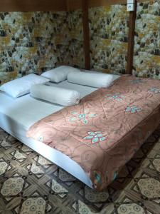 two beds in a room with flowers on them at Mapaddegat Surf House in Simpatdegat