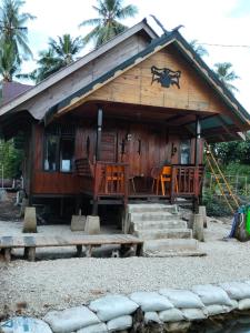 a small wooden house with some chairs and stairs at Mapaddegat Surf House in Simpatdegat