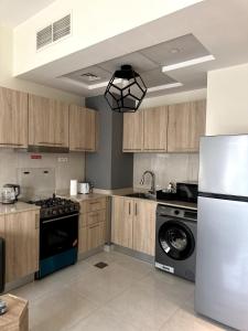 a kitchen with a refrigerator and a dishwasher at Canal View Studio in AG Tower in Sabkhah