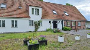 a white house with plants in front of it at Klockargården Örja byväg 17 in Landskrona