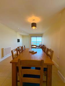 a dining room with a large wooden table and chairs at West Beach - Holiday Apartments in Westward Ho