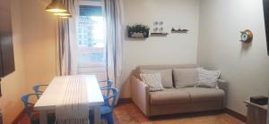 a living room with a couch and a table and a window at Erizana in Baiona