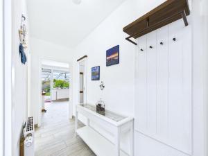 a hallway with white walls and a white door at Huus Buttje in Dornum