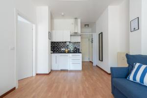 a living room with a blue couch and a kitchen at Elegant Apartments Rapallo in Rapallo
