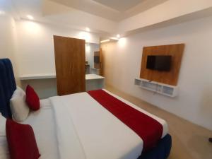 a bedroom with a large bed and a television at Hotel Mysuru Haven in Mysore