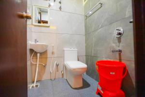 a bathroom with a toilet and a sink at Hotel Mysuru Haven in Mysore