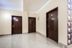 a row of three brown doors in a hallway at Super Hotel O Royal Pearl Inn in Guwahati