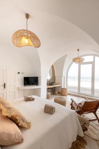 a white bedroom with a bed and a chair at La Perle Ostuni in Ostuni +65 photos
