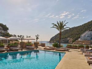 - une piscine avec chaises longues et un complexe dans l'établissement Hyde Ibiza, à Cala Llonga