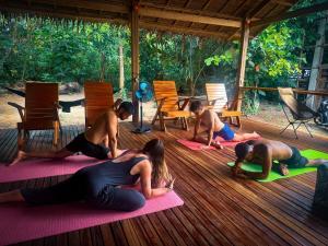 Eine Gruppe von Menschen, die auf einem Deck Yoga machen in der Unterkunft Sunset Surf Hostel Siargao in General Luna