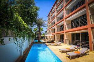 an image of a swimming pool in front of a building at Rawai Beach - 1 BR Cozy Condo in Nai Harn Beach