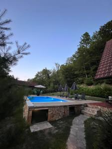 バニャ・ルカにあるDunja Cabin - Forest House with Poolの家の隣の庭のスイミングプール