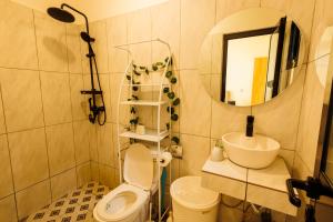 a bathroom with a toilet and a sink and a mirror at Villa Blanche in Douala +5 photos