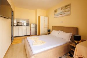 a bedroom with a large bed and a kitchen at Villa Blanche in Douala
