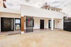 a large white building with a black door at Villa Blanche in Douala
