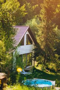 a small white house in the middle of a forest at Sonna in Pidzakharychi
