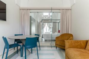 a living room with a table and chairs and a bed at Hydeout Palace - Luxury & Spa Suites by Wonderful Italy in San Vito dei Normanni