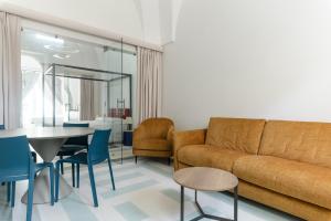 a living room with a couch and a table and chairs at Hydeout Palace - Luxury & Spa Suites by Wonderful Italy in San Vito dei Normanni