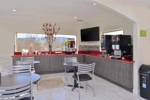 a kitchen with tables and chairs and a counter at Americas Best Value Inn & Suites - Houston/Hwy 6 & Westpark in Houston