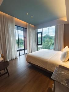 a bedroom with a large bed and large windows at Guanlu Art Hotel in Huadu