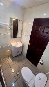 a bathroom with a toilet and a sink and a door at Résidence saint James in Douala