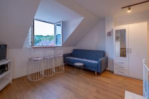 a living room with a blue couch and a window at 086 Studio Apartment in Cetinje