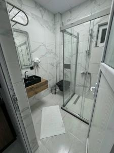 a bathroom with a glass shower and a sink at Gökçe Apart & Pansiyon Amasra in Amasra