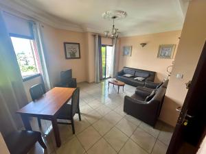 a living room with a table and a couch at Résidence saint James in Douala