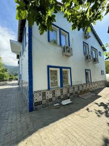 a white building with blue windows on a street at Gökçe Apart & Pansiyon Amasra in Amasra