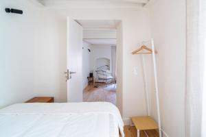 Un dormitorio blanco con una cama y un escritorio. en Fonte da Vila House, en Castelo de Vide
