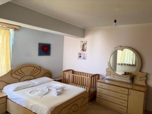 ein Schlafzimmer mit einem Bett, einem Spiegel und einer Kommode in der Unterkunft Klea Noel in Orikum