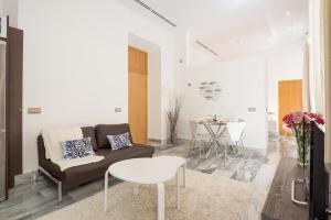 Plaza Picasso في مالقة: غرفة معيشة مع أريكة وطاولة