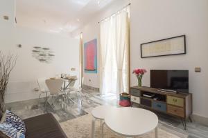 Plaza Picasso في مالقة: غرفة معيشة مع تلفزيون وطاولة