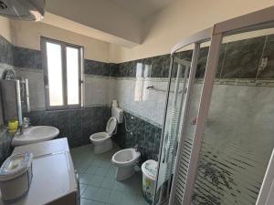 ein Badezimmer mit Dusche, Toilette und Waschbecken in der Unterkunft Klea Noel in Orikum