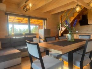 a dining room with a table and a couch at Domki Nad Stawem Mazury D3 in Mrągowo