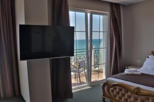 a bedroom with a flat screen tv on a wall at Hotel Amelia Mare in Golem