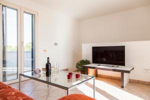 a living room with a glass table and a tv at Salento Mare Daniela in Leuca