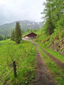 un camino de tierra que conduce a una casa en una colina en TauernBergAlm, en Winkl Heiligenblut