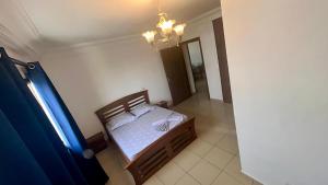 a bedroom with a bed and a chandelier at Résidence saint James in Douala