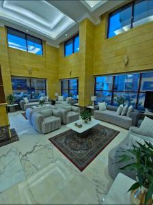 a large living room with couches and tables and windows at شقق جوين للوحدات السكنية المفروشة- اقتصادي in Jeddah