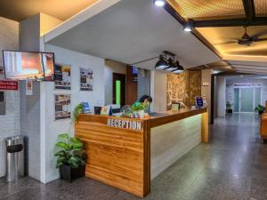 a reception area of a restaurant with a woman sitting at a counter at 18 Coins Budget Hotel in Pattaya Central