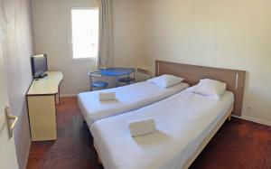 a hotel room with two beds and a television at Appart'City Classic Saint-Nazaire Centre in Saint-Nazaire