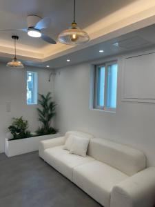 a white living room with a white couch and windows at SRR Stay in Gwangmyeong
