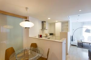 Una cocina y un comedor con una mesa de cristal. en Durlet Rambla Mar Apartments, en Barcelona 60 fotos más