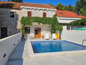 a villa with a swimming pool in front of a house at Villa Dragi in Klek