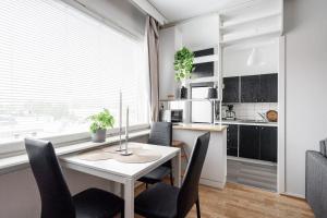 a kitchen and dining room with a table and chairs at Comfy Downtown Studio at Prime Location in Jyväskylä