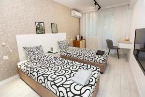 a bedroom with two beds and a desk at D-home in Sofia